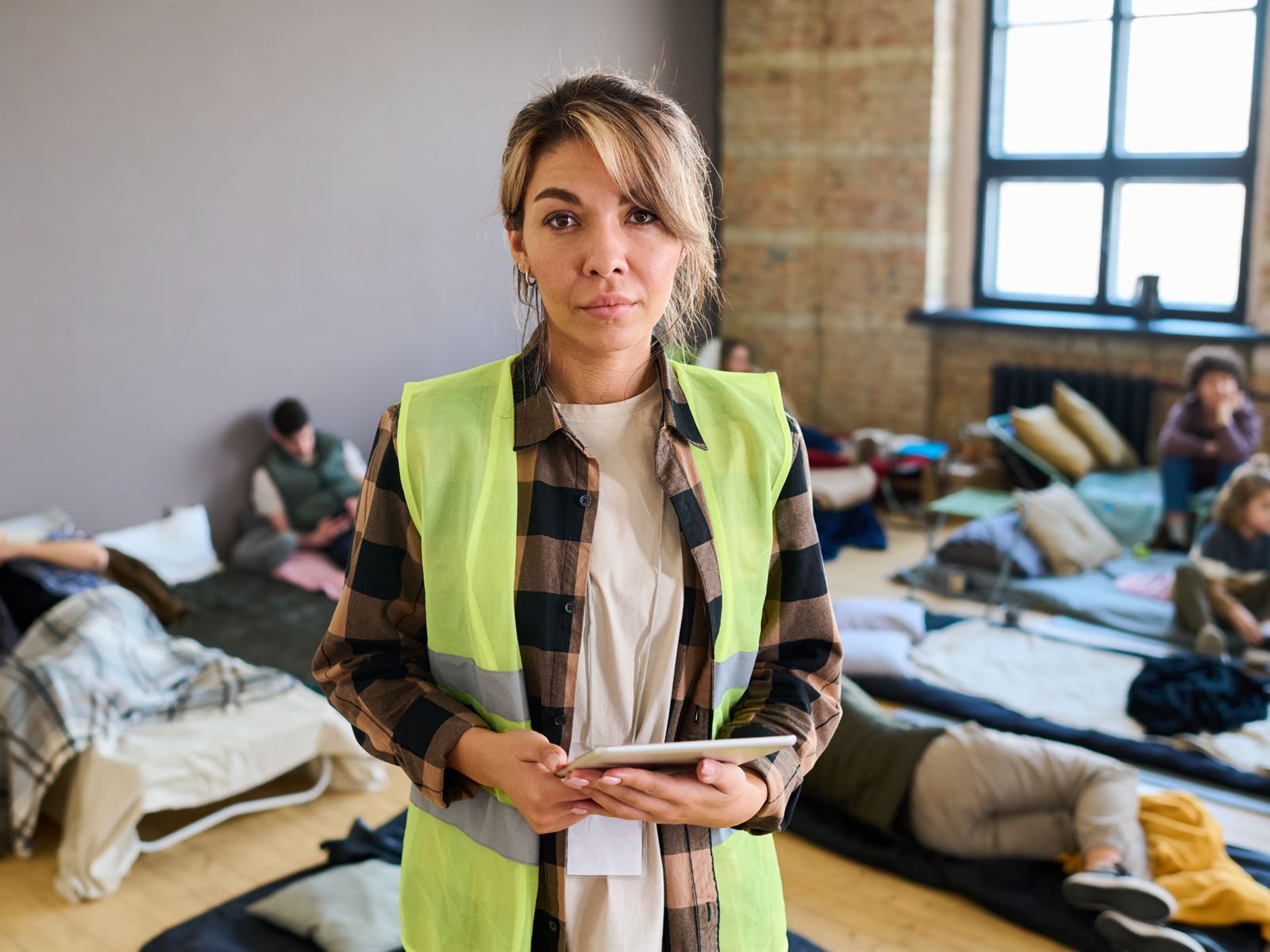 Shelter staff member holding a tablet in a dormitory
